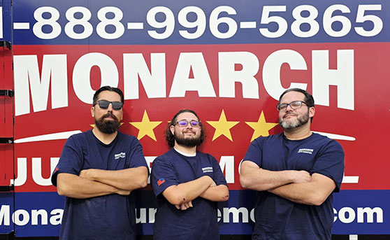 Monarch Junk Removal Employees in front of truck and phone number